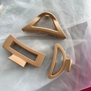 Three-piece geometric hair claw set in matte soft beige with metal springs on tulle