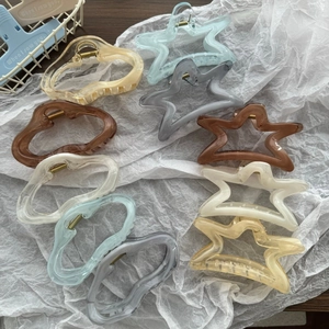 Macro shot of large translucent star and cloud hair claws in assorted modern colors
