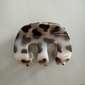 Detail view of large leopard print claw clip showing acetate texture and firm teeth structure