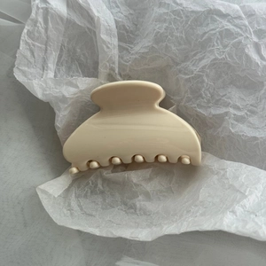 Close-up of a glossy cream PC fan-shaped hair claw clip with smooth resin finish