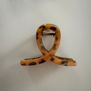 Close-up of tortoise shell hair claw clip with leopard pattern and metal spring