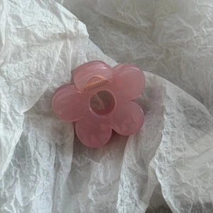 Close-up of pink flower hair claw clip with transparent acrylic petals and metal spring