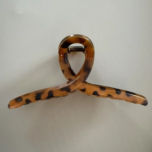 Detail view of large leopard print hair claw clip with strong metal spring and resin texture