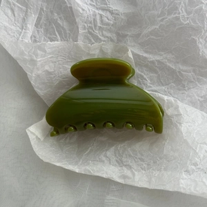 Detail of avocado green hair claw clip with glossy semi-transparent jelly texture