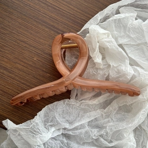 Dettaglio della grande molletta per capelli da 15 cm in acetato ambrato con design a croce