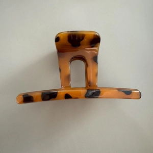 Top view of a large leopard print hair claw clip with amber tortoise shell texture