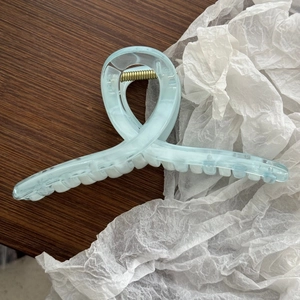 Dettaglio della molletta per capelli azzurra in acrilico con molla in metallo dorato