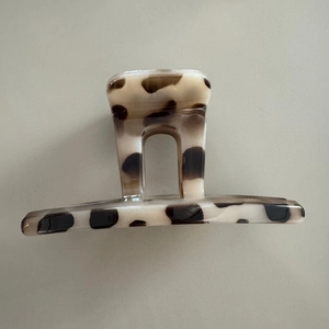 Macro view of leopard print hair claw clip with cream base and dark brown spots