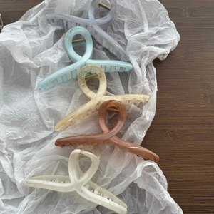 Dettaglio di cinque grandi pinze per capelli da 15 cm con texture a inchiostro colorate