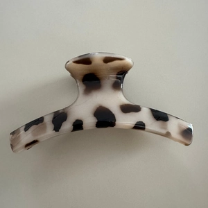 Close-up detail of leopard print hair claw clip with smooth beige and coffee patterns