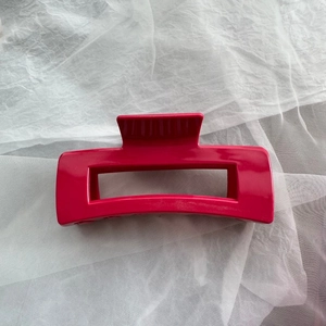 Detailed view of large hot pink matte finish shark hair claw clip for women's hairstyling