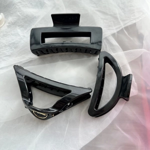 Detailed view of three black geometric soft silicone hair claws on white fabric