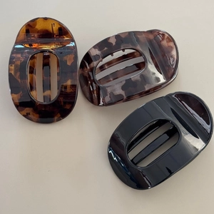 Three-piece oval hollow hair claws in classic black, tortoiseshell, and amber patterns