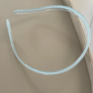 Detail of light blue transparent headband showing anti-slip inner teeth and smooth resin texture