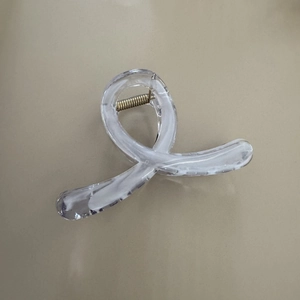 Détail d'une pince à cheveux en résine avec motif marbré blanc et ressort doré robuste