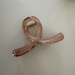 Détail de la pince à cheveux élégante en résine ambrée avec ressort en métal doré