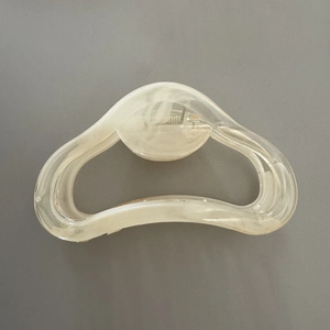 Detail einer großen Haarklammer in Creme-Marmor-Optik mit ausgehöhltem Design