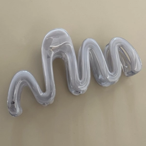 Detail of wavy translucent white resin hair claw clip with a marble texture effect