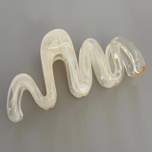 Detail view of large wavy marble hair claw clip with cream jelly patterns and metal spring