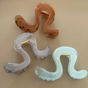 Three wavy S-shaped hair claw clips in amber brown, elegant purple and fresh blue
