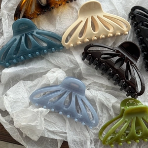 Pinces à cheveux élégantes en forme d'éventail creux, coloris variés sur papier blanc