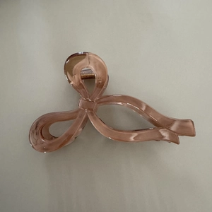 Macro shot of large amber ribbon hair claw clip showing durable gold metal spring detail
