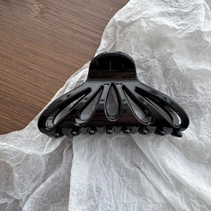 Grande pince à cheveux noire brillante en forme d'éventail avec un design creux élégant