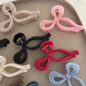 Dettaglio di pinze per capelli a fiocco colorate con finitura lucida e molla in metallo