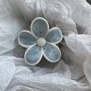 Vue détaillée de la pince à cheveux florale avec motifs marbrés et pétales bleu pastel élégants