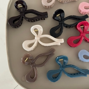 Eleganti mollette per capelli a fiocco in vari colori disposte su un vassoio