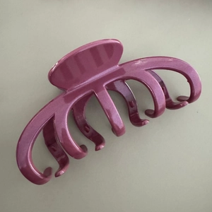 Détail de la pince à cheveux mauve avec finition nacrée et dents arrondies pour la coiffure