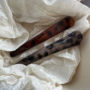 Close-up of leopard print acetate duckbill hair clips with polished Paris engraving detail