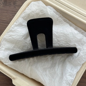Detail of elegant black flocked hair claw clip with a matte finish and U-shaped design
