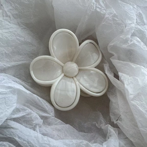 Gros plan sur la pince à cheveux fleur blanc crème avec texture marbrée