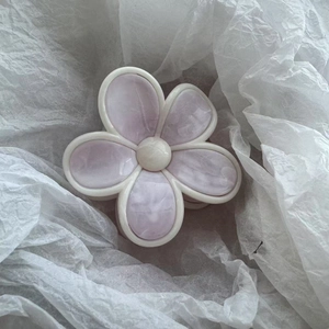 Détail d'une pince à cheveux en forme de fleur avec nacre violette et bord blanc