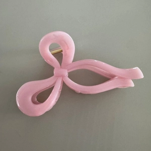 Dettaglio della molletta per capelli a fiocco rosa con struttura a molla in metallo