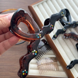 Grande pince à cheveux vague avec strass colorés en marron foncé et noir brillant