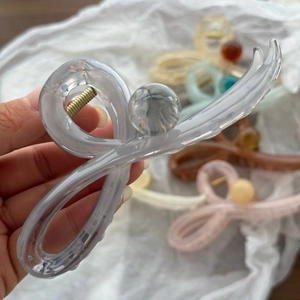 Dettaglio di eleganti mollette per capelli in acetato traslucido in vari colori neutri