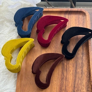 Détails de grandes pinces à cheveux floquées en cinq couleurs sur un plateau en bois