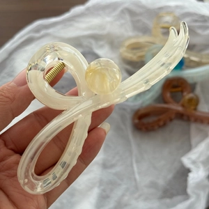 Dettaglio di un grande fermaglio per capelli in acrilico marmorizzato con molla dorata