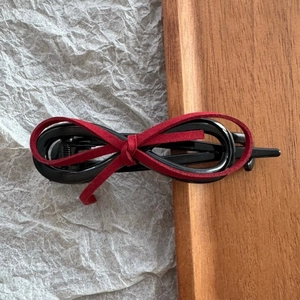 Detailed macro view of red suede bow tie hair clip with black glossy base texture