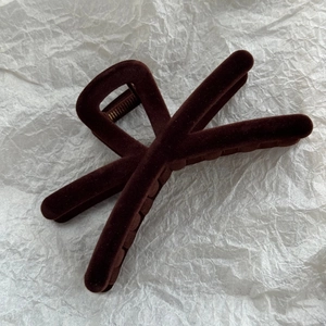 Détail de la pince à cheveux floquée marron café avec une conception de dents croisées