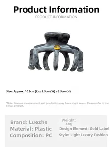 Detail of grey marble textured hair claw clip with golden believe brand label