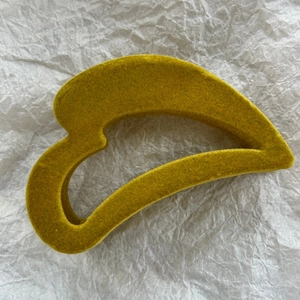 Détail de la texture floquée douce jaune moutarde sur cette pince à cheveux minimaliste