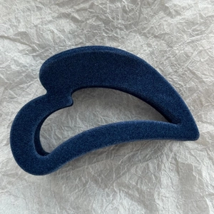 Vue détaillée de la pince à cheveux feuille bleu foncé avec une texture veloutée mate douce