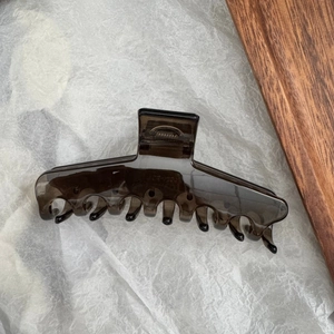 Détail d'une grande pince à cheveux marron translucide avec ressort solide et dents de prise