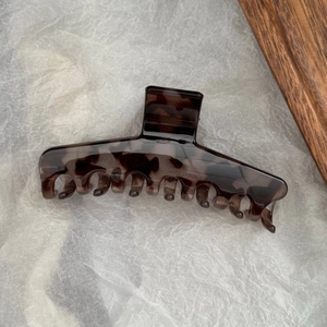 Détail de la pince à cheveux en PC motif écaille de tortue foncée sur fond blanc