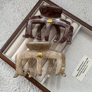 Set of two large marble texture hair claws in dark brown and beige with gold logos
