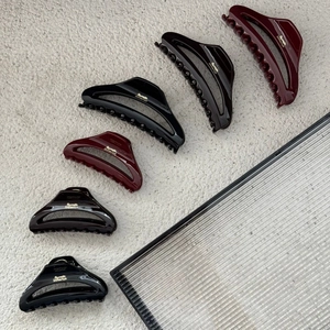 Detailed close-up of glossy crescent hair claw clips with Barrette La France gold lettering