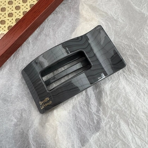 Détail de la pince à cheveux rectangulaire marbré gris foncé avec lettrage doré élégant